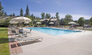 a swimming pool with lounge chairs and umbrellas at Lake Forest Glen # 117 By Hauserman Rentals in Tahoe City