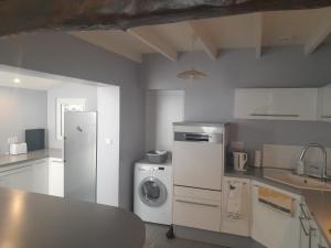 a kitchen with a refrigerator and a washing machine at Place Georges Brassens in Cahors +1 photo