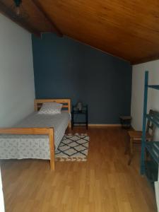 a bedroom with a bed and a blue wall at Place Georges Brassens in Cahors