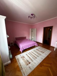 a pink bedroom with a bed and a rug at Felicità Family Club 
