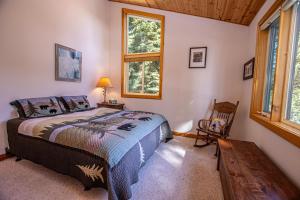 Un dormitorio con una cama y una silla y una ventana. en KT22 View By Hauserman Rentals, en Olympic Valley