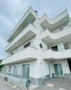 Un edificio blanco con balcones a los lados. en Casa Buono Holidays, en Isquia