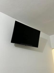 a flat screen tv hanging on a white wall at Hotel del Pueblo in Teotitlán del Valle
