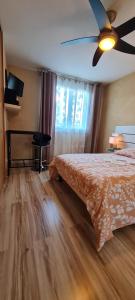 Appartement VANILLE في لو بونت دي كليكس: غرفة نوم بها سرير ومروحة سقف