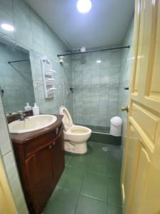 a bathroom with a toilet and a sink at Acogedor departamento familiar en Ibarra in Ibarra