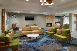 a lobby with couches and chairs and a tv at Fairfield Inn and Suites Charleston North/University Area in Charleston
