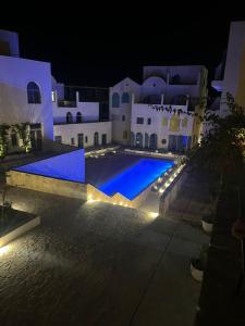 a night view of a swimming pool with lights at Drymades Ruci Rooms in Dhërmi