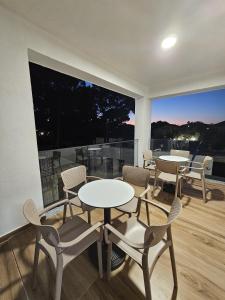 a room with tables and chairs and a large window at Victoria Houses, Vlore Albania in Vlorë