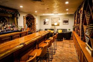 a bar with chairs and a long counter in a room at Historic Santa Maria Inn in Santa Maria