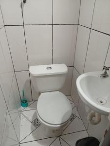 a white bathroom with a toilet and a sink at Casa aconchegante in Ouro Preto