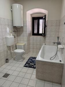 a bathroom with a tub and a toilet and a sink at Villa#12 in Savina +12 photos