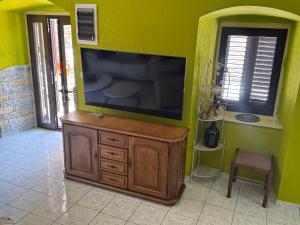 a living room with a flat screen tv on a green wall at Villa#12 in Savina