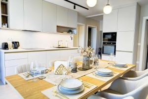 a kitchen and dining room with a wooden table and chairs at By The Lakeside Apartment in Balatonlelle