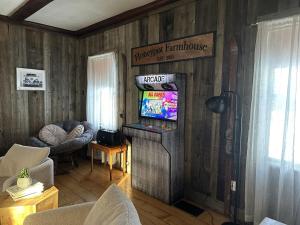 a living room with a television and a couch at Honeypot Farmhouse - Lux Family Retreat at Okemo - Bromley in Weston