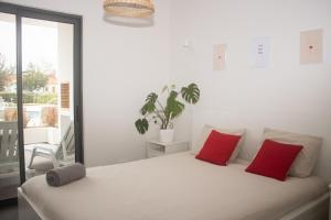 a bedroom with a bed with two red pillows at Apartament Alvor in Albur Village Lote A in Alvor +15 photos