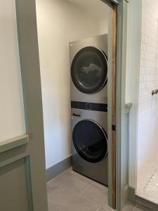 a washer and dryer in a small bathroom at Honeypot Farmhouse - Lux Family Retreat at Okemo - Bromley in Weston +31 photos