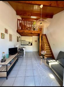 a living room with a couch and a staircase at Petite maison dans les Landes in Saint-Julien-en-Born