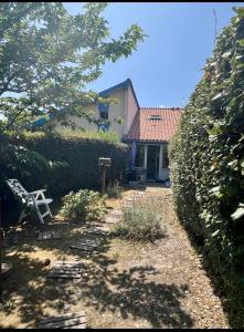 a garden in front of a house with a hedge at Petite maison dans les Landes in Saint-Julien-en-Born