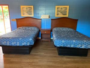 Dos camas en una habitación con paredes azules. en Royal inn, en Quincy