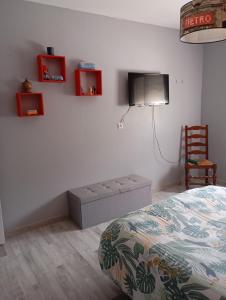 a bedroom with a bed and a flat screen tv at Maison de village in Saint-Loup +3 photos