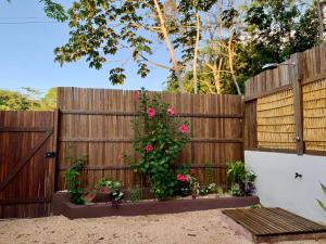 a wooden fence with pink roses on it at Canto Carauari Pousada in Alter do Chao