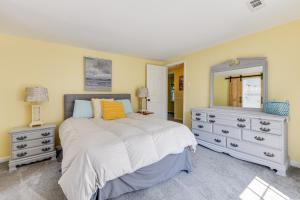 a bedroom with a bed and a dresser and a mirror at Stroll, Shop and Dine Cozy Colonial Beach Bungalow in Colonial Beach