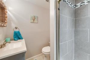 a bathroom with a shower and a toilet and a sink at Stroll, Shop and Dine Cozy Colonial Beach Bungalow in Colonial Beach +23 photos