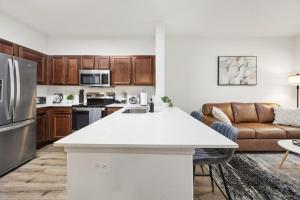 a kitchen and living room with a large white counter top at Brightshaven CoolSprings, Modern 1Bed with EV Parking in Frisco in Frisco