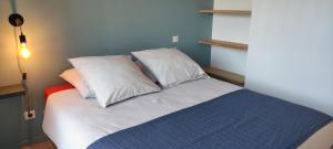 a bed with three pillows on it in a room at Gîte Larrun Lodge in Sare