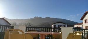 a table and chairs on a balcony with mountains at Gîte Larrun Lodge in Sare