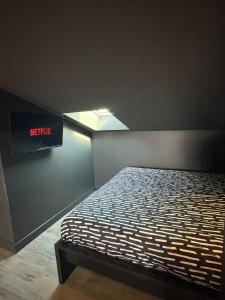 a bed in a room with a sign on the wall at racing room in Bressuire
