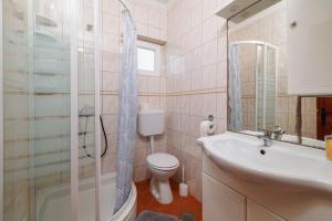 a bathroom with a toilet and a sink and a shower at Apartments Anica J in Lopar +98 photos