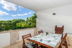 a dining room with a table and chairs on a balcony at Apartment Diana in Povljana