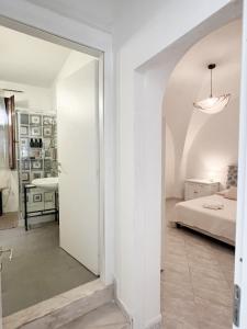 a white room with a bed and a mirror at Casa Maristé in Favignana