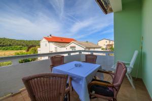 Una mesa y sillas en un balcón con vista. en Apartments Petar, en Kampor