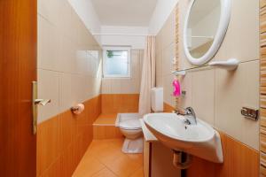 Un baño con lavabo, inodoro y espejo. en Apartments Petar, en Kampor 60 fotos más