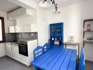 a kitchen with a blue table and blue chairs at Casa Maristé in Favignana +23 photos