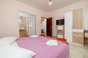 Un dormitorio con dos camas con toallas encima. en Apartments Petar, en Kampor