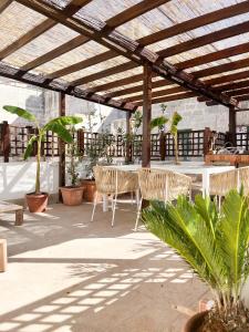a patio with a table and chairs under a pergola at Casa Maristé in Favignana