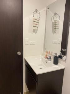 a bathroom with a white sink and a mirror at Central, Universidades y Centro Comercial in Manizales +10 photos