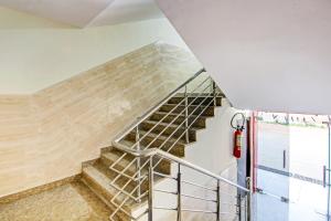 a staircase in a building with a metal handrail at Hotel O Island in Meerut