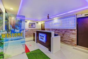 a lobby with a tv and a welcome sign on a wall at Hotel O Island in Meerut +27 photos