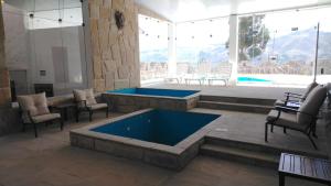 a large room with a large pool with chairs and a table at Xima Colca in Yanque