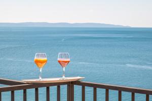 zwei Gläser Wein auf einem Tisch mit Meerblick in der Unterkunft Apartments Sinovcic with terrace & sea view, 4 min walk to the beach in Podstrana