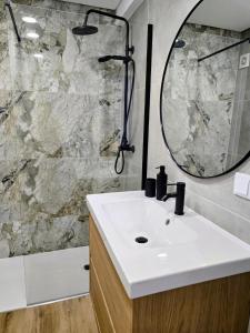 Un baño con lavabo, ducha y espejo. en Stay in Faro Riamar, en Faro