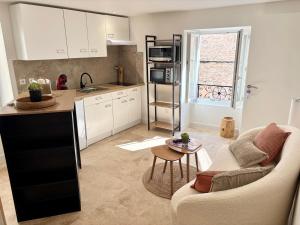 eine Küche und ein Wohnzimmer mit Sofa und Tisch in der Unterkunft Chaleureux T1 avec Balcon in Vals-les-Bains + 2 Fotos