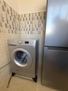 eine Waschmaschine in einer Küche neben einem Kühlschrank in der Unterkunft Chez simo in Tangier