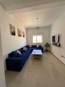 ein Wohnzimmer mit einem blauen Sofa und einem Tisch in der Unterkunft Chez simo in Tangier