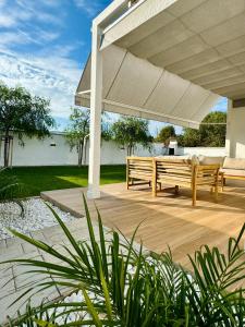 a patio with two benches under a large umbrella at Loft luxury Mirador in Cádiz