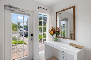 a white bathroom with a mirror and a sink at Heat of Siesta Village Walk to Beach w heated Pool in Siesta Key